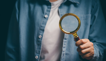 Hand holding magnifying glass, verification awareness, careful inspection mindset, analytical...