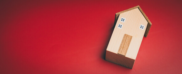 Wooden house on red background, home security awareness, stability reflection, property protection insight, financial planning support, safe housing and emotional comfort concept