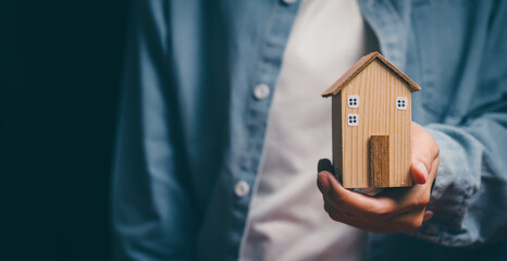 Hand holding wooden house, home security awareness, property protection stability, financial planning support, housing responsibility insight, reassurance and safe home value concept