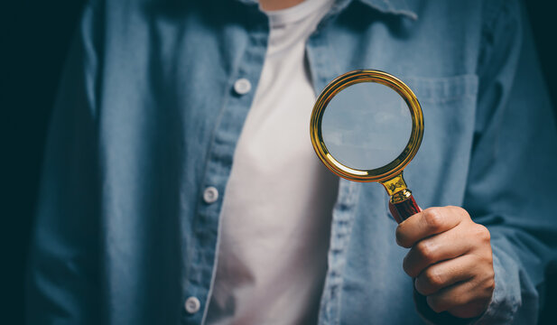 Hand holding magnifying glass, verification awareness, careful inspection mindset, analytical thinking support, detail investigation insight, accuracy responsibility and review concept