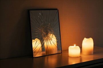 Candles reflected in broken mirror