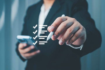 Businessman marking a correct check sign on a quality control checklist, symbolizing approval,...