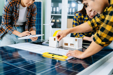Three colleagues discussing data working and tablet, laptop with on on architectural project at construction site at desk in office