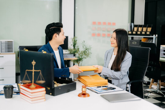 justice and law concept.passing bribe money in the envelop at lawyer office.