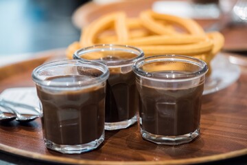 Enjoying rich chocolate drinks with sweet churros in a cozy cafe setting during an afternoon gathering