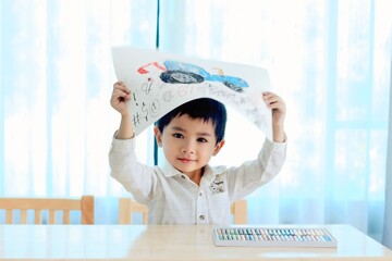 Cute boy learning to draw and color