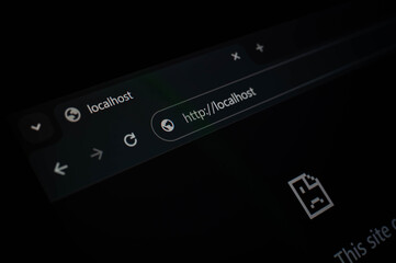 Close-up of a web browser showing a localhost address bar, commonly used by developers and programmers for testing websites on a local server environment. Dark theme concept.