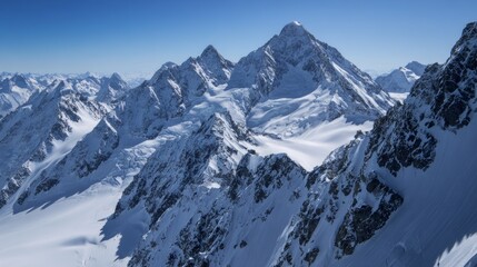 Obraz premium Aerial view of snow-covered Alps with a clear blue sky, showcasing breathtaking natural beauty and majestic mountain peaks.