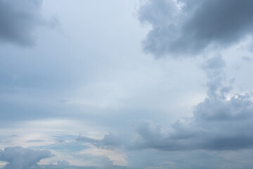 Overcast sky with layers of gray and white cumulus clouds against a light blue background