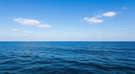 Obraz premium Horizontal Seascape with Ocean and Sky in Equal Parts. Tranquil Blue Seascape with Gentle Waves and Clouds. Serene Ocean View with Fluffy White Clouds.
