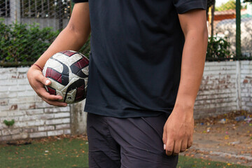 An unrecognizable man holding a ball in his hands