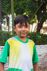 Portrait of a boy Colombian soccer player smiling and looking at the camera inside a sports club in Neiva, Huila, Colombia. Concept of childhood and happiness