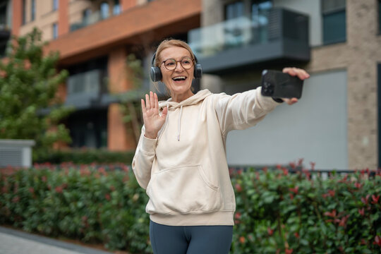 Happy senior woman making video call waving hand