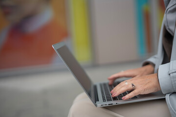 Fototapeta premium Woman's hands typing on laptop keyboard working remotely