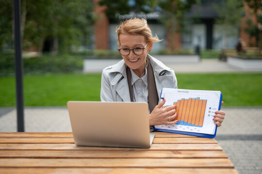 Senior woman presenting sales chart in a video call - Powered by Adobe