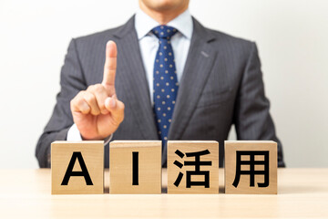 「AI活用 」と書かれたブロックとビジネスマン