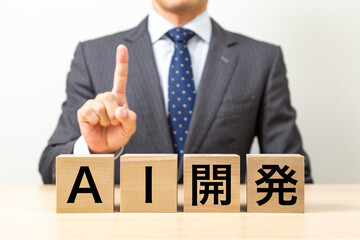 「AI開発」と書かれたブロックとビジネスマン
