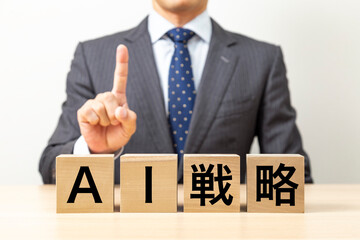 「AI戦略 」と書かれたブロックとビジネスマン