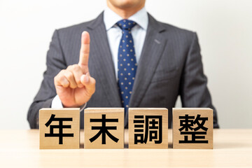 「年末調整」と書かれたブロックとビジネスマン