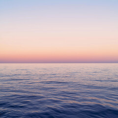 Obraz premium Calm ocean water with serene pastel sunset creating a peaceful scene for travel and meditation uses