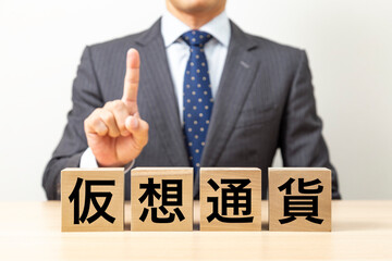 「仮想通貨」と書かれたブロックとビジネスマン