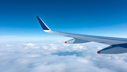 Fototapeta premium Airplane Window View. Airplane Wing Flying Above the Clouds and Blue Sky.