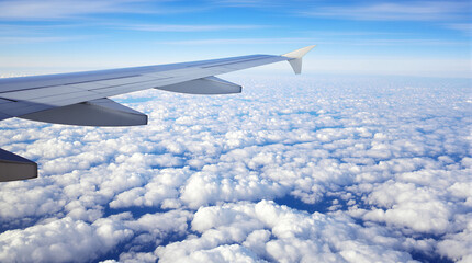 Obraz premium Stunning Airplane Window View of the Wing Above the Clouds and Blue Sky