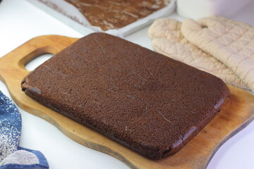 Freshly baked chocolate cake on a wooden cutting board