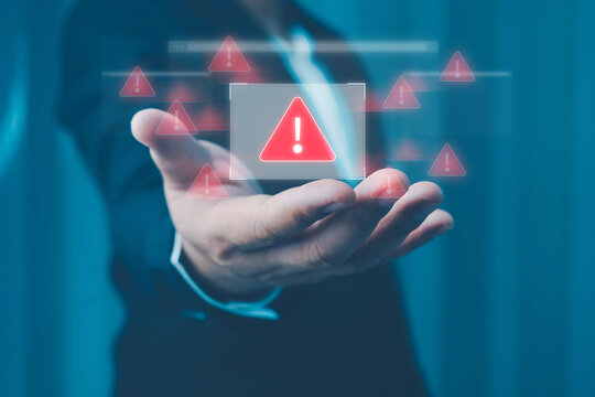 System warning alert on a virtual interface with hand interaction, illustrating cybersecurity risks, data breaches, malware threats, hacking, and digital system vulnerabilities.