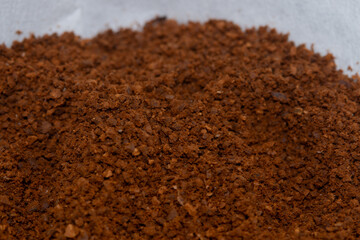 Super macro close-up of medium roast coffee powder prepared for drip brewing.