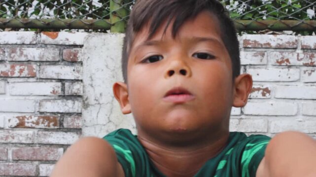 A Colombian boy in a uniform is doing a resistance and strength test during soccer practice on a field in Neiva, Huila, Colombia. Concept of childhood and healthy lifestyle