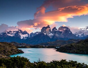 Stunning vista of mountains with snow-capped peaks reflecting in a turquoise lake under a dramatic, colorful sky