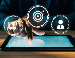 Person using a tablet with digital icons of shopping cart target and user interface overlayed on screen