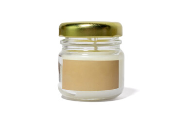 Front view of a small white candle in a clear glass jar with a golden lid and a blank beige label, isolated on a white background.