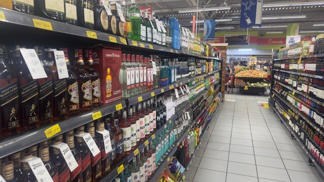 BELO HORIZONTE, MG/BRAZIL - November 16 2025: An aisle stocked with various brands of alcoholic beverages including whiskeys, gins, vodkas, and wines in a supermarket.
