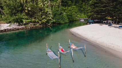 Relaxing in hammocks on the tranquil waters of Koh Kood Island, Thailand