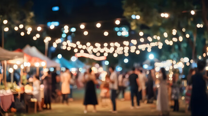 Fototapeta premium Blurry nighttime outdoor gathering illuminated by string lights