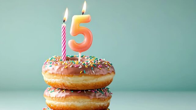 Stack of donuts with candles for a fifth birthday celebration. Sweet treat.