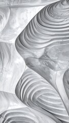 Close-up view of abstract, organic, layered shapes with swirling, fluid, grey tones