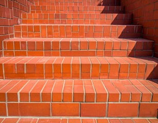 Close-up view of bright orange brick steps with grout lines, lit with bright sunlight
