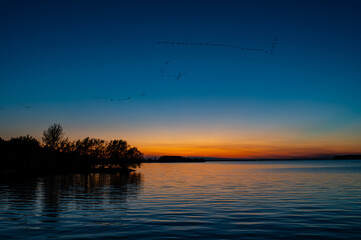 Twilight Landscape Over Calm Lake After Sunset — Deep Blue and Orange Horizon