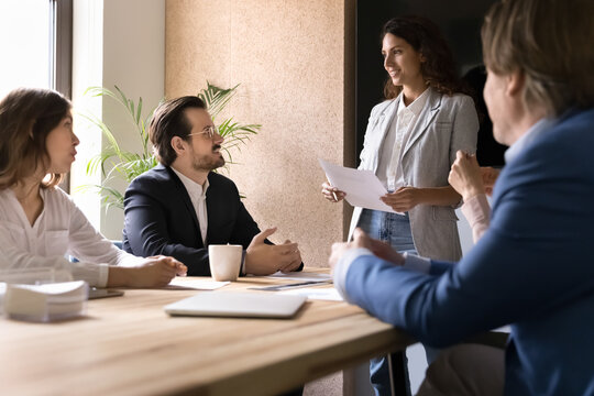 Confident young female business team leader speak at corporate meeting