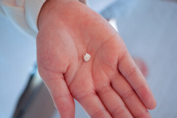 歯が抜けた！初めての乳歯を見せる女の子のクローズアップ