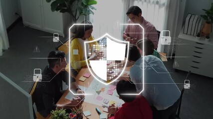 Diverse team of professionals collaborate in a modern office, focusing on cybersecurity strategies with digital security graphics overlay, showcasing innovation and problem-solving. Raster - Powered by Adobe