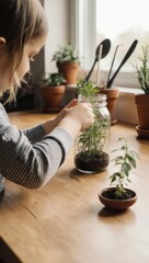 Young girl tending to small plants in a glass jar on a wooden counter.
