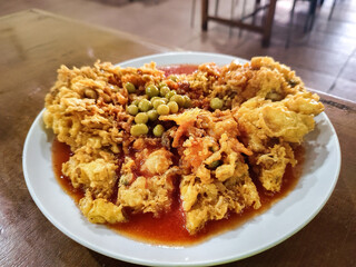 Delicious homemade fuyunghai, a crispy Chinese-style omelette with sweet and sour sauce served on a white plate