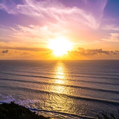 A vibrant sunset casts golden and purple hues across the ocean. Rippling water reflects light from the sun, illuminating the cloudy sky