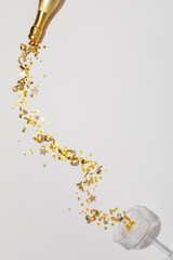 Party New Year or Christmas background with champagne glass and bottle with golden confetti stars....