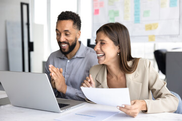 Two cheerful diverse office colleagues and friends having fun