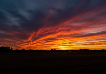 Obraz premium Dramatic evening sky ablaze with brilliant fiery colors reflecting across the horizon during the peaceful twilight hour ,tropical ,glowing ,warm